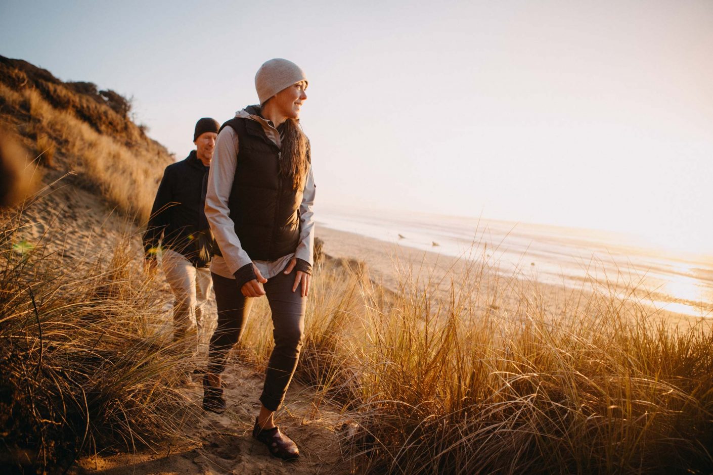 Couple walking on Woolacombe beach during Autumn holiday in North Devon