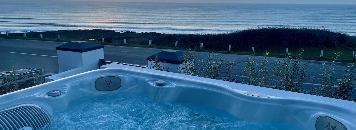 Hot tub with sea view in the background and sunset